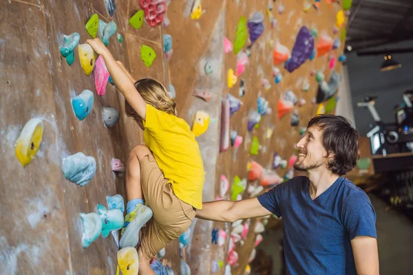 Dad and son at the climbing wall. Family sport, healthy lifestyle, happy family