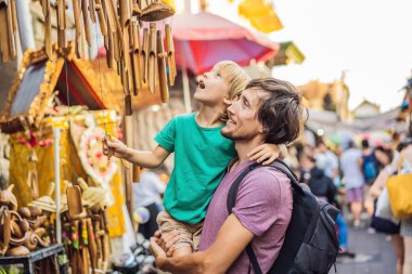 Baba ve oğlu Ubud, Bali'de bir markette. Ünlü Ubud Market, Endonezya'da Hediyelik eşya ve Bali el sanatları satan tipik hediyelik eşya dükkanı. Bali pazarı. Ahşap hediyelik eşya ve yerel el sanatları