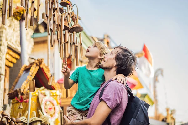 Papà e figlio al mercato di Ubud, Bali. Negozio di souvenir tipico che vende souvenir e artigianato di Bali presso il famoso mercato di Ubud, Indonesia. Mercato balinese. Souvenir di legno e artigianato locale — Foto Stock