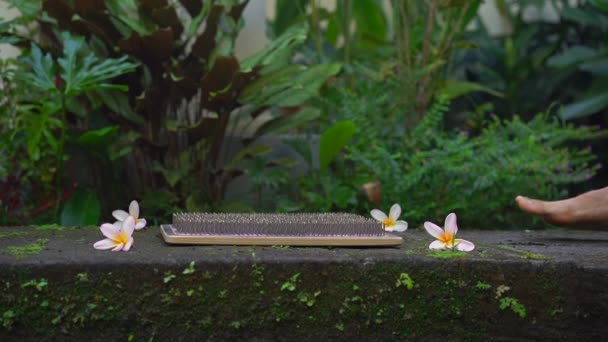 Zeitlupenaufnahme eines jungen Mannes, der ein Sadhu-Brett oder Nagelbrett in einer tropischen Umgebung benutzt — Stockvideo