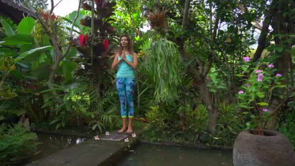 Zeitlupenaufnahme einer jungen Frau, die ein Sadhu-Brett oder Nagelbrett in tropischer Umgebung benutzt — Stockvideo