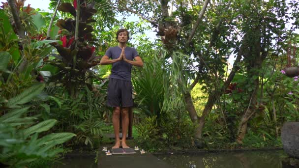 Fotografía en cámara lenta de un joven que usa una tabla Sadhu o una tabla de clavos en un entorno tropical — Vídeos de Stock