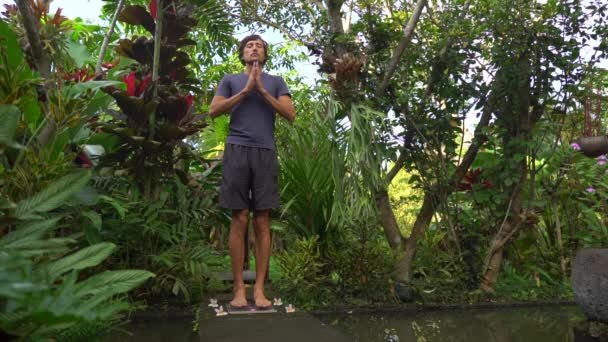 Fotografía en cámara lenta de un joven que usa una tabla Sadhu o una tabla de clavos en un entorno tropical — Vídeo de stock