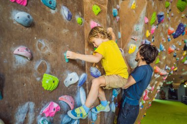 Baba ve oğlu tırmanma duvarında. Aile sporu, sağlıklı yaşam tarzı, mutlu aile