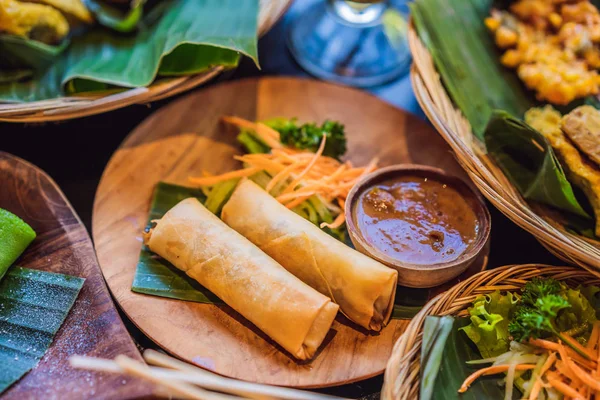 Roti gulung pegas goreng disajikan dengan salad dan saus. Hidangan tradisional Indonesia dan Asia — Stok Foto