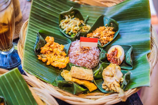 Nasi lemak, nasi campur, indonesischer balinesischer Reis mit Kartoffelfritter, Satellilit, gebratenem Tofu, pikant gekochten Eiern und Erdnüssen — Stockfoto