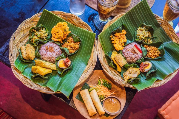 Nasi lemak, Nasi campur, nasi Bali Indonesia dengan kentang goreng, sate lilit, tahu goreng, telur rebus pedas, dan kacang tanah — Stok Foto