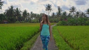 Yoga matematik güzel bir pirinç alanında yürürken genç bir kadının Slowmotion steadicam atış