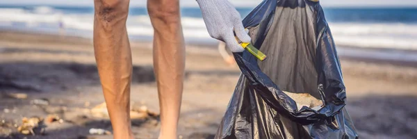 Молодой человек убирает пляж. Естественное воспитание детей BANNER, LONG FORMAT — стоковое фото