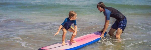 Ojciec lub instruktor nauczania jego 5-letniego syna, jak surfować w morzu na wakacjach lub wakacjach. Podróże i Sport z koncepcją dla dzieci. Lekcja surfingu dla dzieci banner, Long format — Zdjęcie stockowe