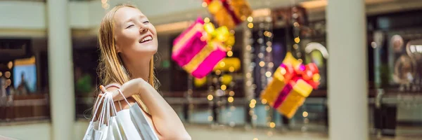 Young woman with purchases in new year shop. Christmas sale, black friday BANNER, LONG FORMAT