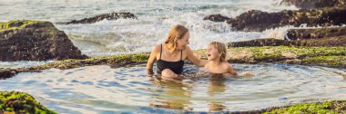 Banner, Uzun Format Anne ve oğlu turistler Pantai Tegal Wangi Beach deniz suyu, Bali Adası, Endonezya bir banyo da oturan. Bali Seyahat Konsepti. Çocuk konsepti ile seyahat. Çocuk dostu