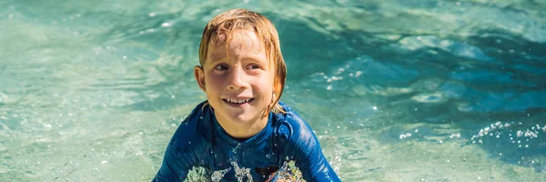 Szczęśliwy chłopiec na zjeżdżalnia w basenie zabawy podczas letnich wakacji w pięknym tropikalnym kurorcie banner, Long format — Zdjęcie stockowe