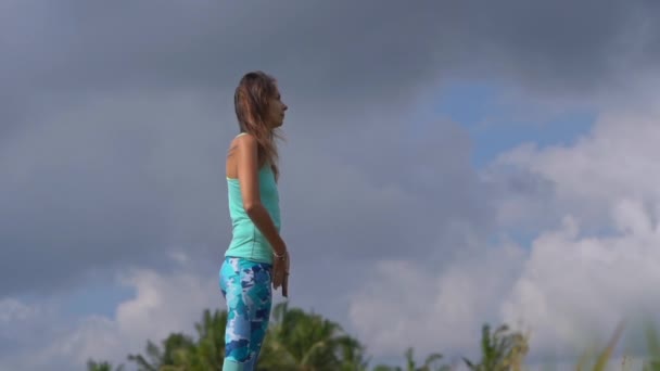 Slowmotion skott av en ung kvinna som tränar yoga på ett vackert risfält — Stockvideo