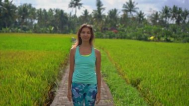 Güzel bir pirinç tarlasında yoga yapan genç bir kadının slowmotion çekimi