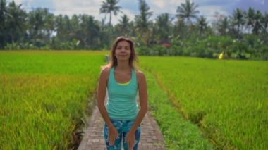 Güzel bir pirinç tarlasında yoga yapan genç bir kadının slowmotion çekimi