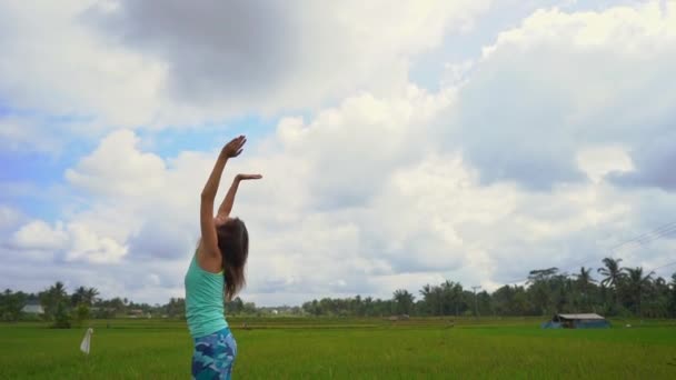 Slowmotion shot of a young woman practicing yoga on a beautiful rice field — Stock Video
