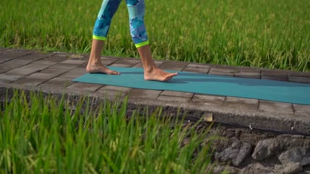 Slowmotion shot of a young woman practicing yoga on a beautiful rice field — Stock Video