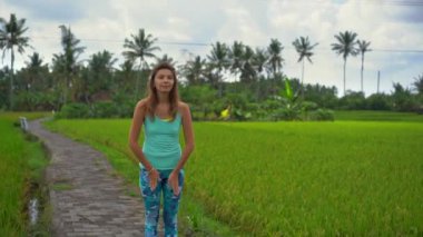 Güzel bir pirinç tarlasında yoga yapan genç bir kadının slowmotion çekimi