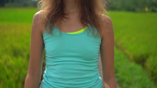 Plan au ralenti d'une jeune femme pratiquant le yoga sur un beau champ de riz — Video