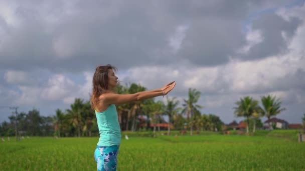 Colpo di rallentatore di una giovane donna che pratica yoga su una bella risaia — Video Stock