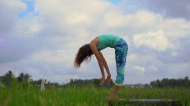 Güzel bir pirinç tarlasında yoga yapan genç bir kadının slowmotion çekimi