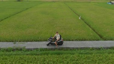 Pirinç tarlasında motosikletli bir adamın havadan çekilmiş fotoğrafı