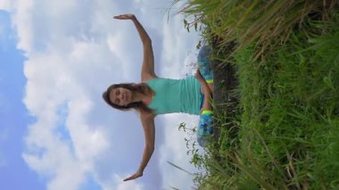 Hikayeler için dikey video. Genç kadın güzel bir pirinç tarlasında yoga yapıyor