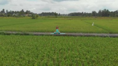 Bali bir şekilde Muladhara çakra için meditasyon yapan genç bir kadının Slowmotion havadan çekim
