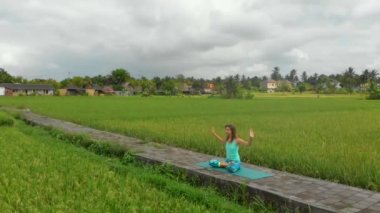 Bali bir şekilde Muladhara çakra için meditasyon yapan genç bir kadının Slowmotion havadan çekim