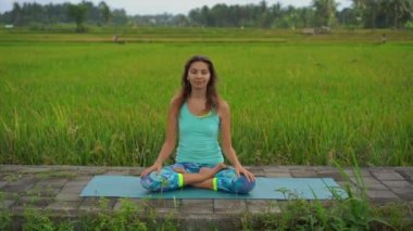 Bali bir şekilde Muladhara çakra için meditasyon yapan genç bir kadının Slowmotion steadicam çekim