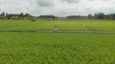 Bali bir şekilde Muladhara çakra için meditasyon yapan genç bir kadının Slowmotion havadan çekim