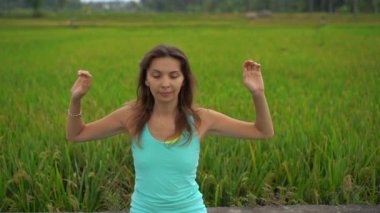 Bali bir şekilde Muladhara çakra için meditasyon yapan genç bir kadının Slowmotion steadicam çekim