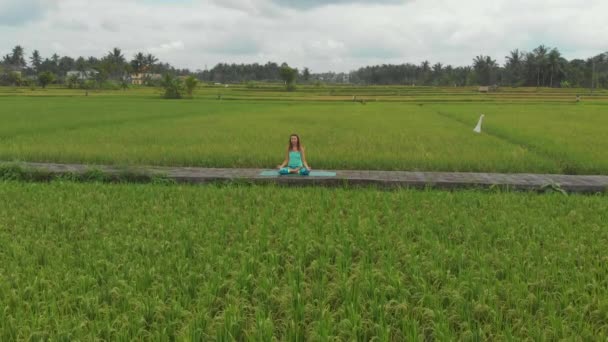 Photo aérienne au ralenti d'une jeune femme qui médite pour le chakra Muladhara d'une manière balinaise — Video