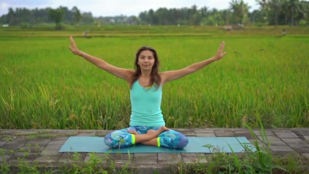 Slowmotion steadicam shot of a young woman doing meditation for Muladhara chakra in a Balinese way — Stock Video