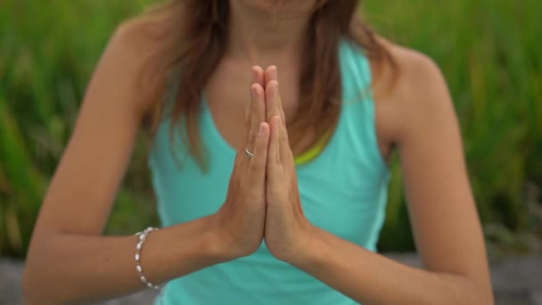 Slowmotion steadicam plan d'une jeune femme faisant de la méditation pour le chakra Muladhara d'une manière balinaise — Video