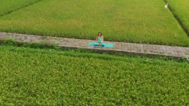 Slowmotion luchtfoto van een jonge vrouw doet meditatie voor Muladhara Chakra in een Balinese manier — Stockvideo