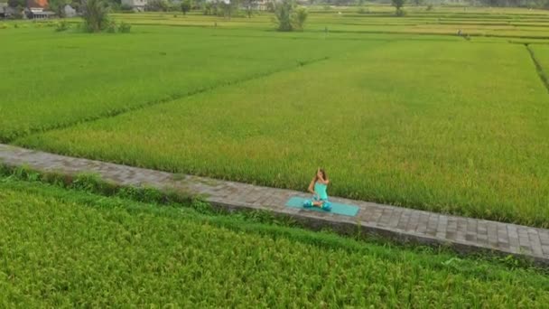 Slowmotion Aerial Shot av en ung kvinna gör meditation för Muladhara Chakra i en balinesisk sätt — Stockvideo