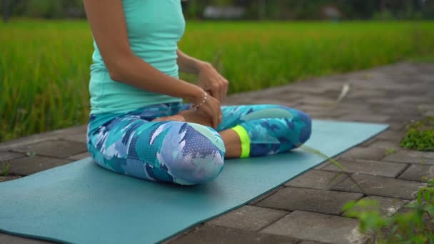 Bali bir şekilde Muladhara çakra için meditasyon yapan genç bir kadının Slowmotion steadicam çekim — Stok video