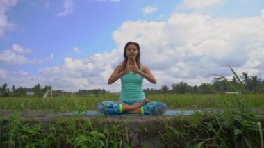 Bali bir şekilde Muladhara çakra için meditasyon yapan genç bir kadının Slowmotion steadicam çekim