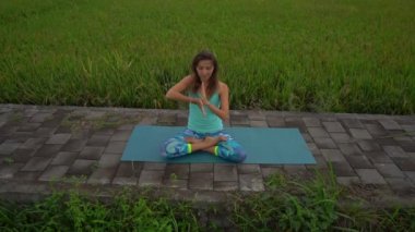 Bali bir şekilde Muladhara çakra için meditasyon yapan genç bir kadının Slowmotion steadicam çekim