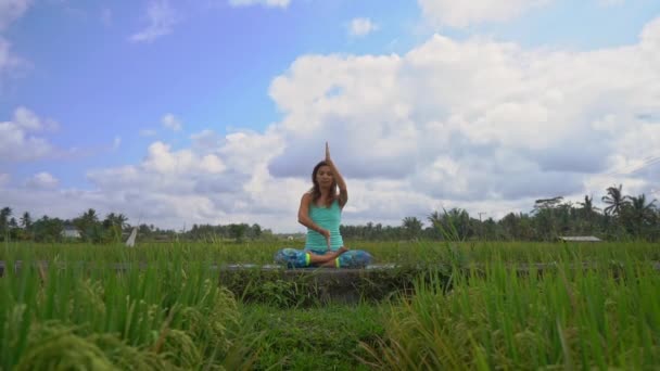 Bali bir şekilde Muladhara çakra için meditasyon yapan genç bir kadının Slowmotion steadicam çekim — Stok video