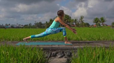 Güzel bir pirinç tarlasında yoga yapan genç bir kadının slowmotion steadicam çekim