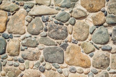 Yuvarlak taşlardan ve beton yoldan yapılmış kaldırım blokları.