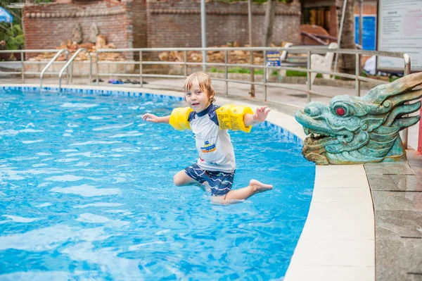 Молодий хлопчик стрибає у воду з басейну — стокове фото