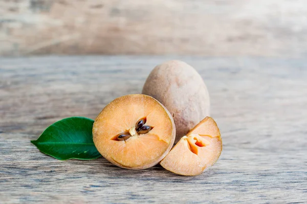 Fruits de sapodilla frais sur un vieux fond en bois — Photo