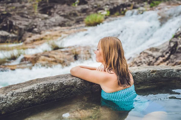 Geothermische Spa. Vrouw ontspannen in warmwaterbron zwembad tegen de achtergrond van een waterval — Stockfoto