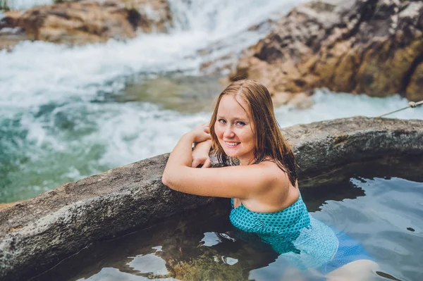 Geothermische Spa. Vrouw ontspannen in warmwaterbron zwembad tegen de achtergrond van een waterval — Stockfoto