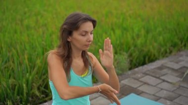 Bali bir şekilde Muladhara çakra için meditasyon yapan genç bir kadının Slowmotion steadicam çekim