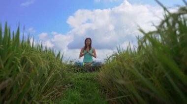 Muladhara çakrası için meditasyon yapan genç bir kadının Bali usulü çekilmiş bir fotoğrafı.